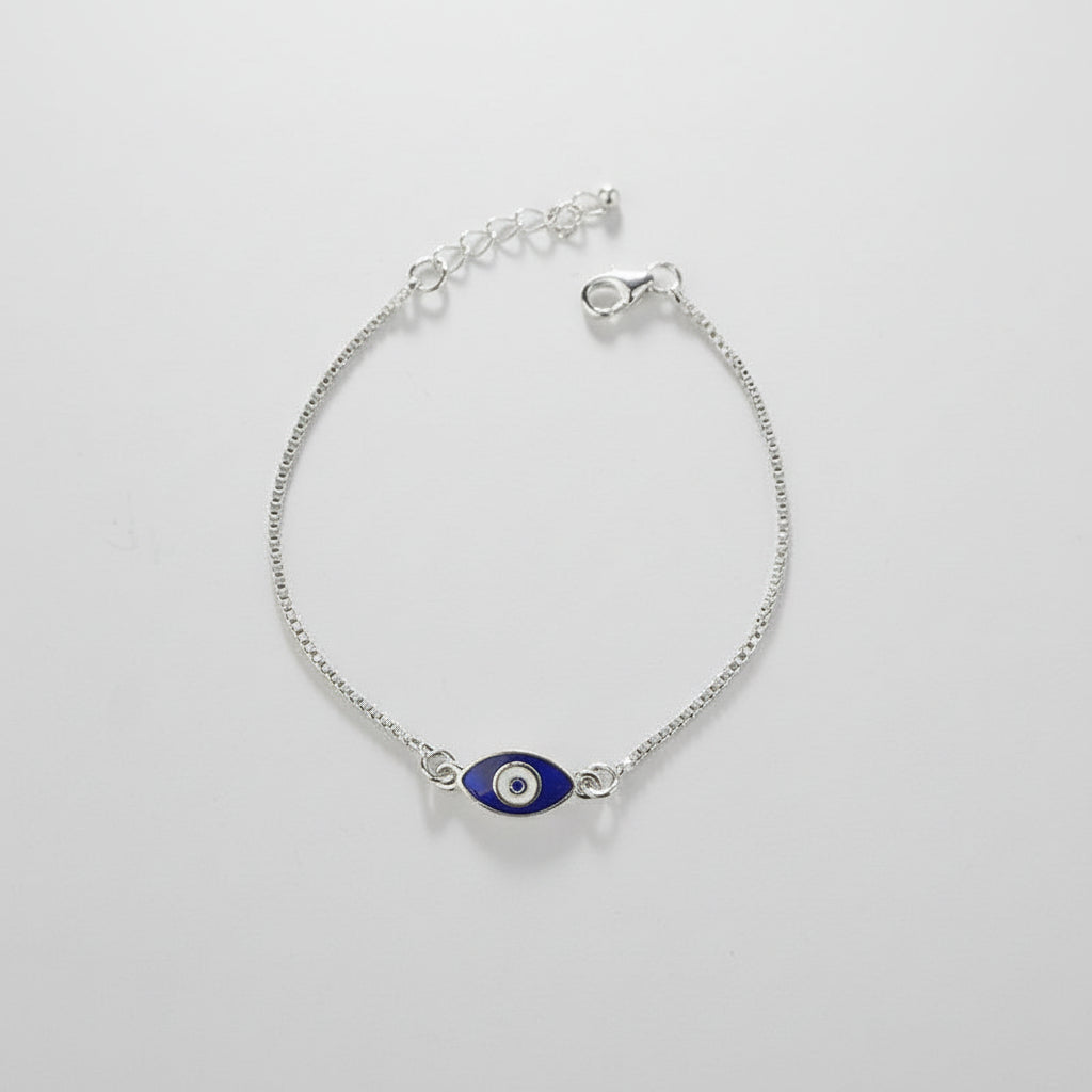 Silver bracelet with a blue evil eye charm on a gray background