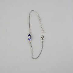 Silver bracelet with a blue evil eye charm on a gray background