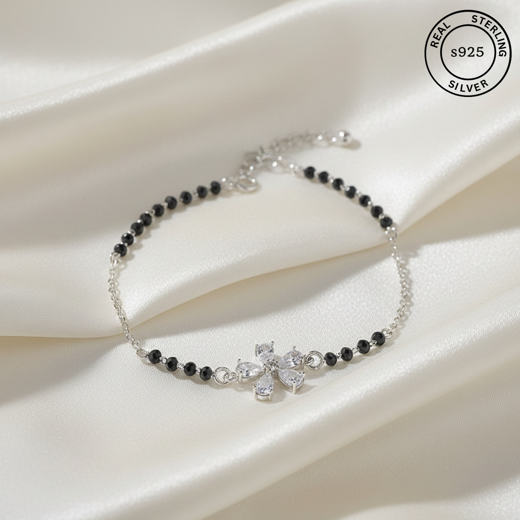 925 Sterling Silver Floral Black Bead Bracelet with black beads and cubic zircons stones on a white fabric background, featuring 'Real Sterling Silver' stamp.
