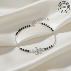 925 Sterling Silver Floral Black Bead Bracelet with black beads and cubic zircons stones on a white fabric background, featuring 'Real Sterling Silver' stamp.