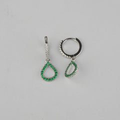 Pair of silver earrings with green gemstones on a gray background