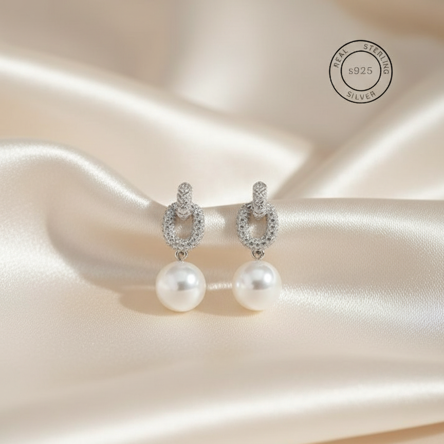 Silver Pearl Drop Dangles
with silver hooks on a satin background, featuring 'Real Sterling Silver' text.