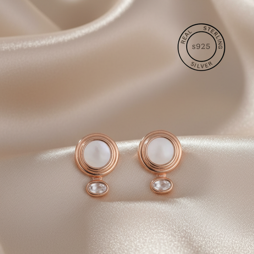 Rose gold earrings with a central MOP on a beige fabric background, featuring a 'Real Sterling Silver' stamp.