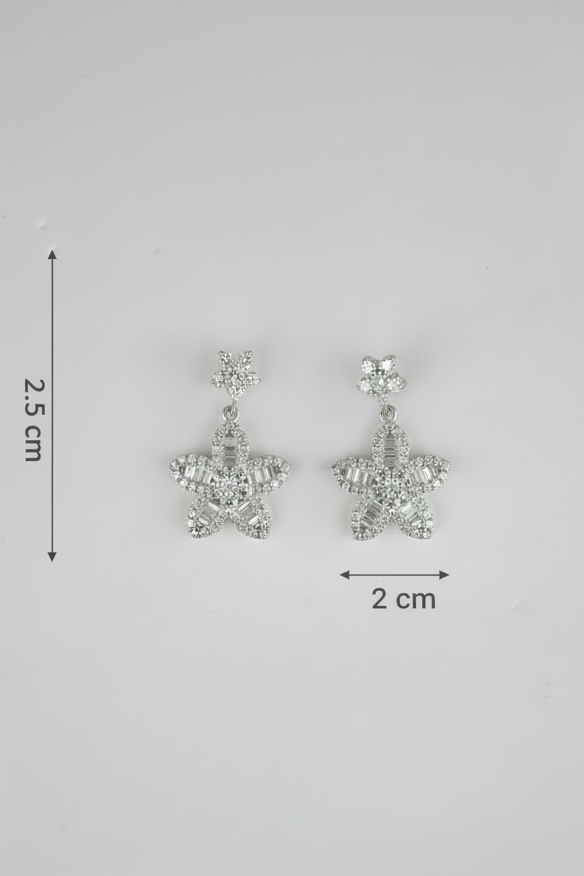 Star-shaped earrings with measurements on a gray background