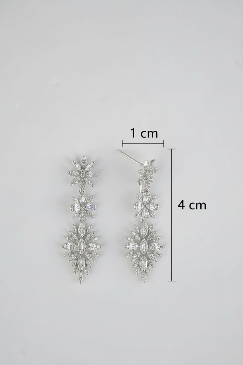 Silver earrings with measurement details on a gray background