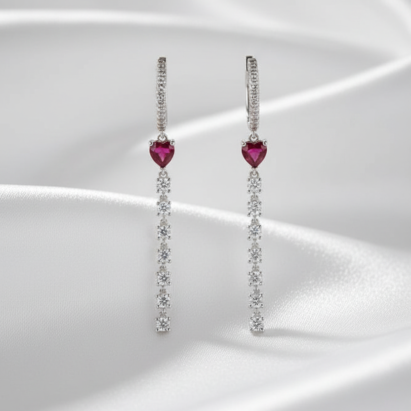 Pair of earrings with heart-shaped gemstones on a white background