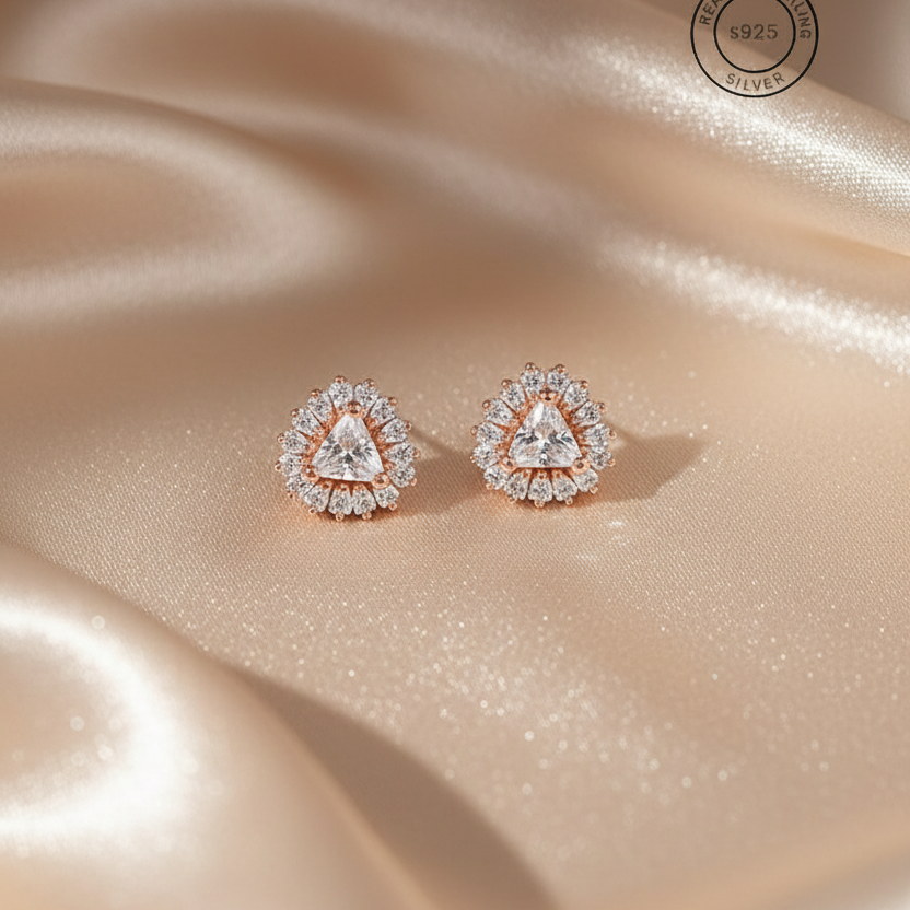 Rose gold earrings with triangular gemstones on a beige satin background, featuring '925' silver stamp.