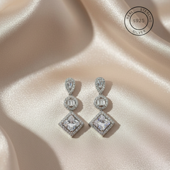 Pair of silver earrings with gemstones, featuring '925 Sterling Silver' stamp.