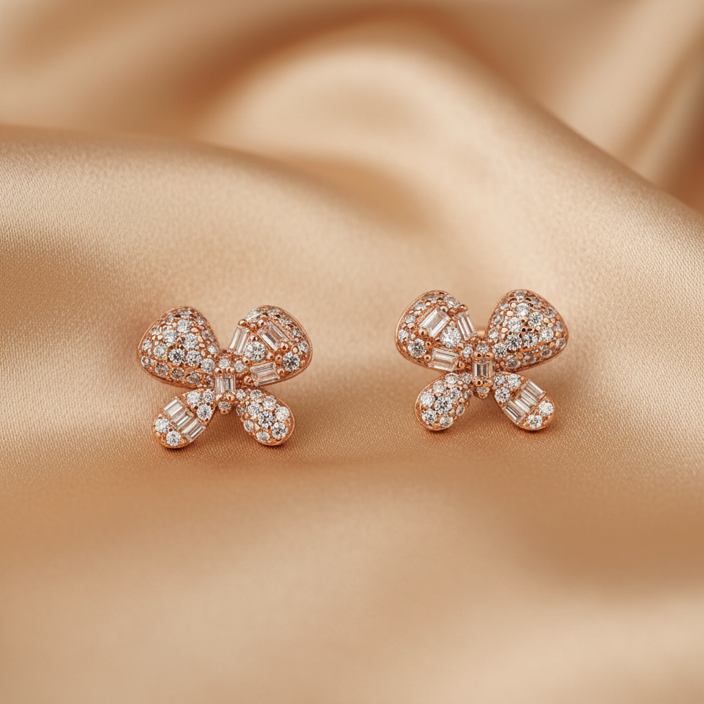 Rose gold bow-shaped earrings with AAA+ Cubic zircons on a beige fabric background