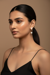 Woman wearing a black top and pearl earrings