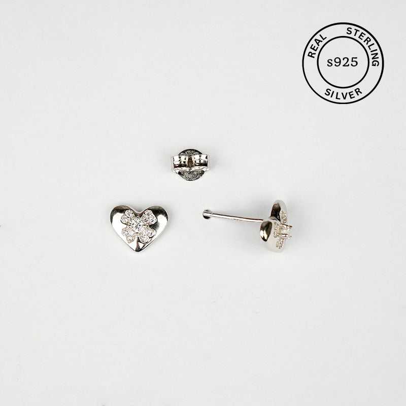 Set of silver heart-shaped earrings with AAA+ CZ stones on a white background, featuring 'Real Sterling Silver' stamp.