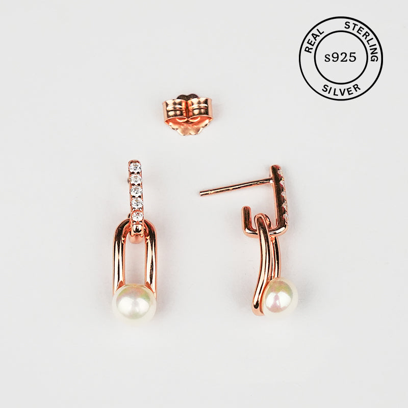 Rose gold earrings with pearl drops on a white background, featuring 'Real Sterling Silver' certification.