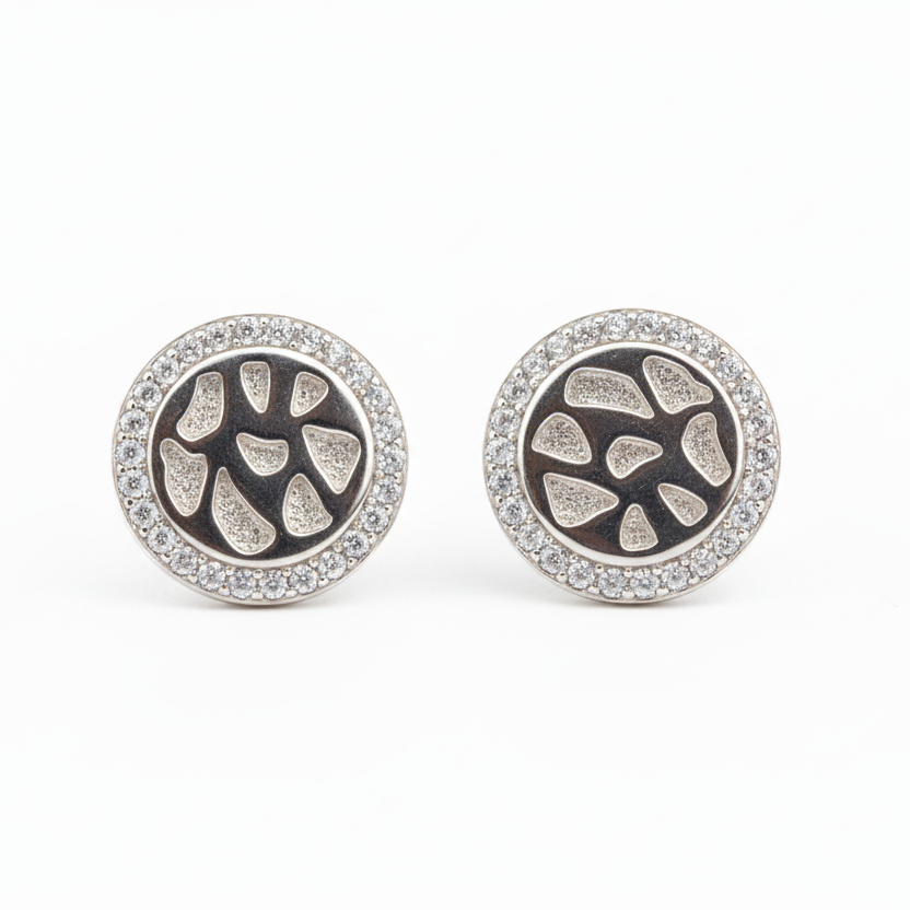 Pair of round earrings with intricate design on a white background