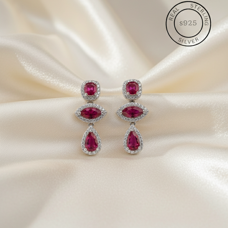 Pair of rani pink gemstone earrings on a satin background with 'Real Sterling Silver' stamp.