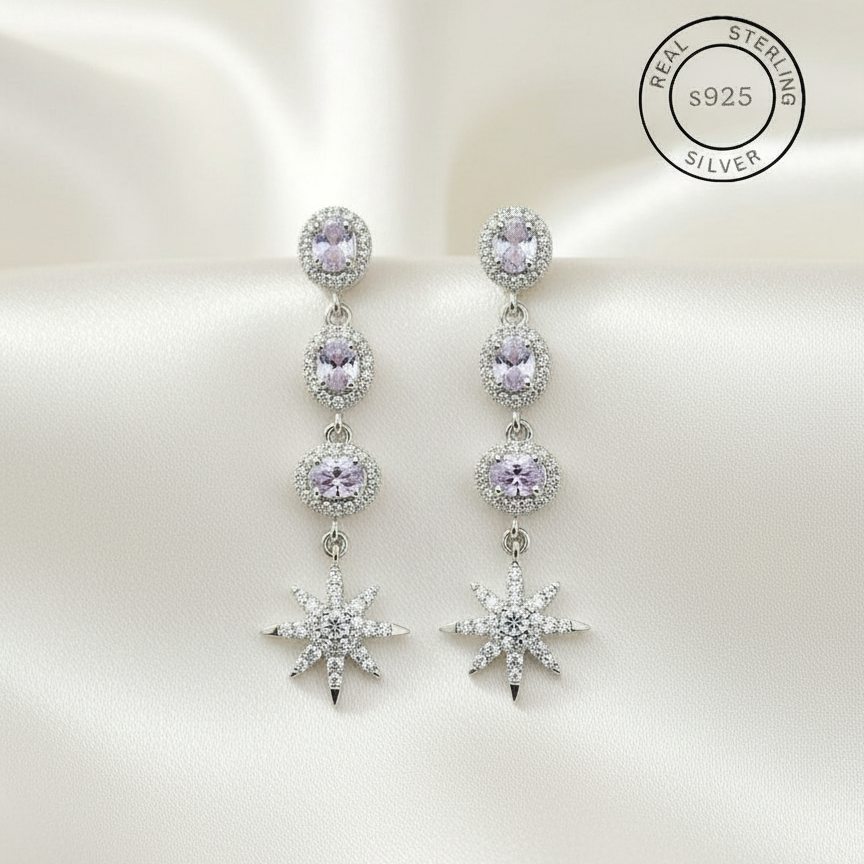 Silver earrings with purple gemstones on a white background, featuring 'Real Sterling Silver' certification.