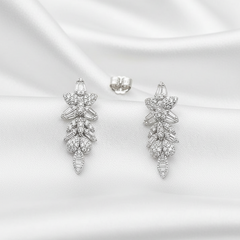 Pair of silver earrings on a white satin background