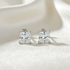 Pair of silver square-cut stud earrings on a light background