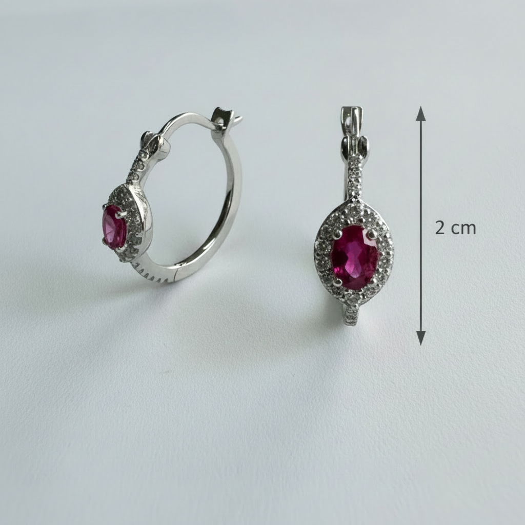 Silver hoop earrings with red gemstones on a light gray background
