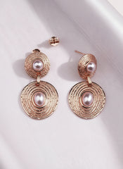 Rose gold earrings with pearls on a white background