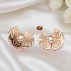 Rose gold earrings with pearl center on a soft white background