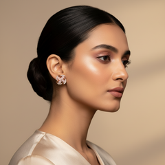 Woman wearing a floral earring against a beige background
