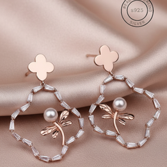 Rosegold Butterfly dangles
 with floral and pearl designs on a satin background