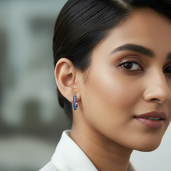 Close-up of a woman wearing blue earrings with a blurred background