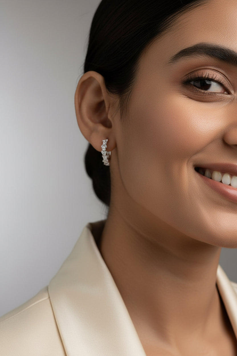 Close-up of a woman wearing diamond earrings with a neutral background
