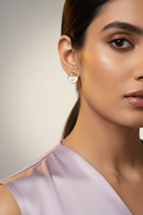 Close-up of a woman wearing gold earrings with mother of pearl stones